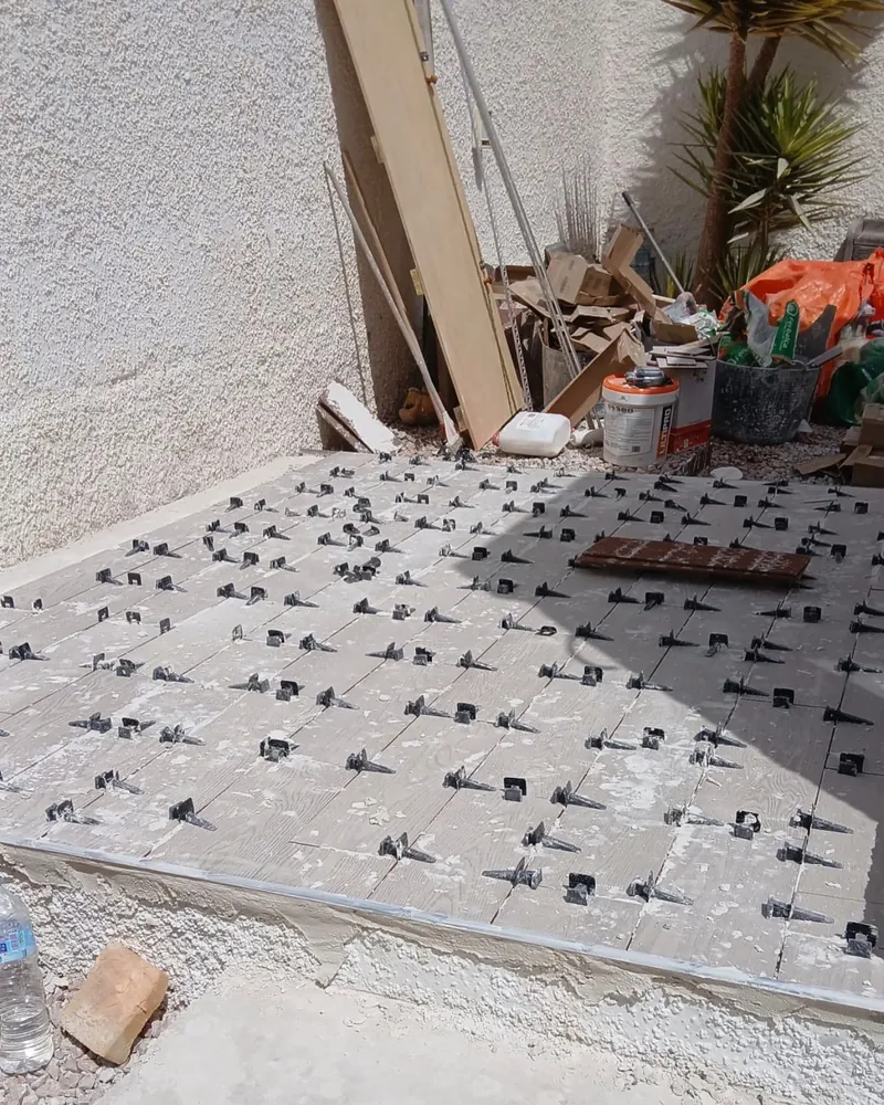 Baldosa gris de gran formato colocada con clips niveladores en las juntas